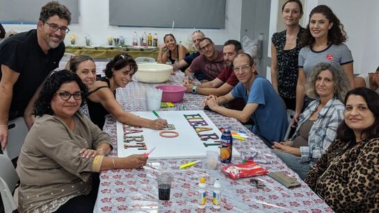 parents of alumni gathered and smiling at an activity in Israel